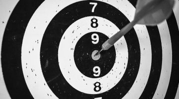 A picture of a target with a dart stuck in the bullseye, showing how important finding your target audience is for Darren and Mike.